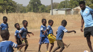 Saviour Anyagri playing soccer with children in Ghana.