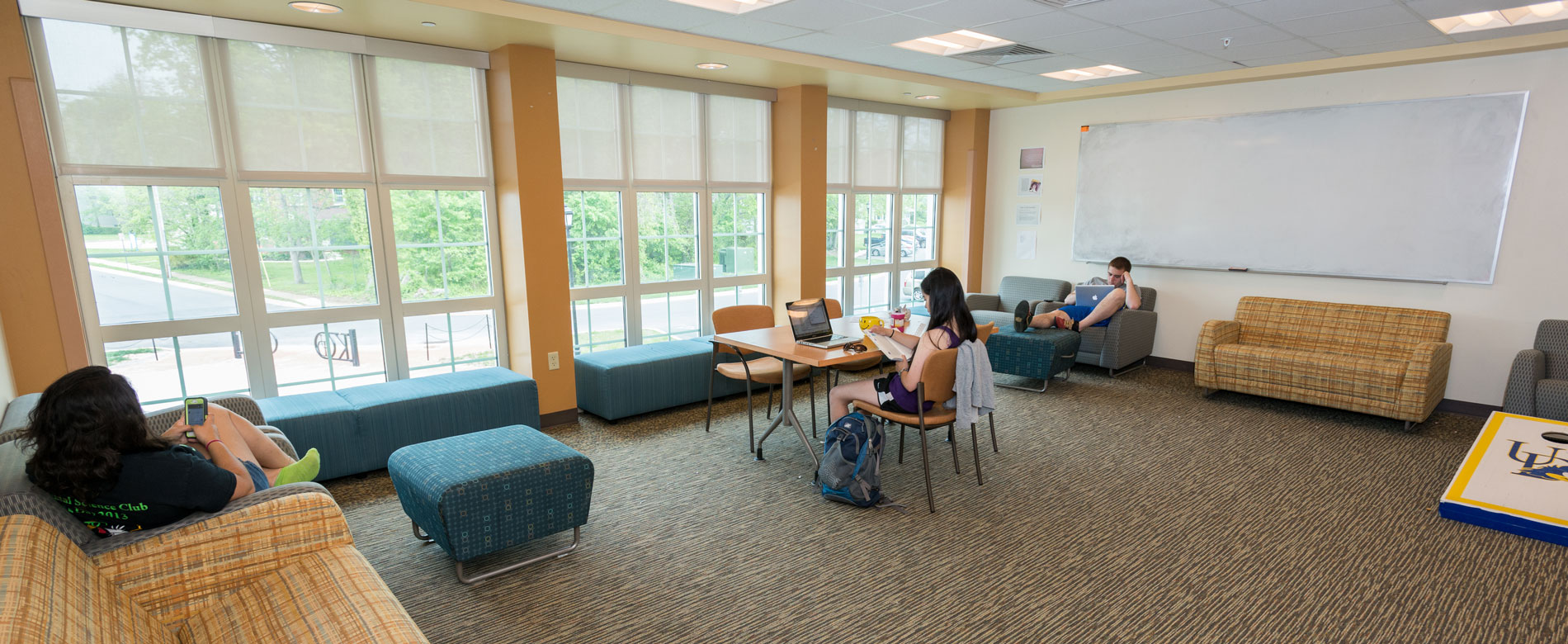 Students relaxing and studying in lounge with comfortable chairs and sofas