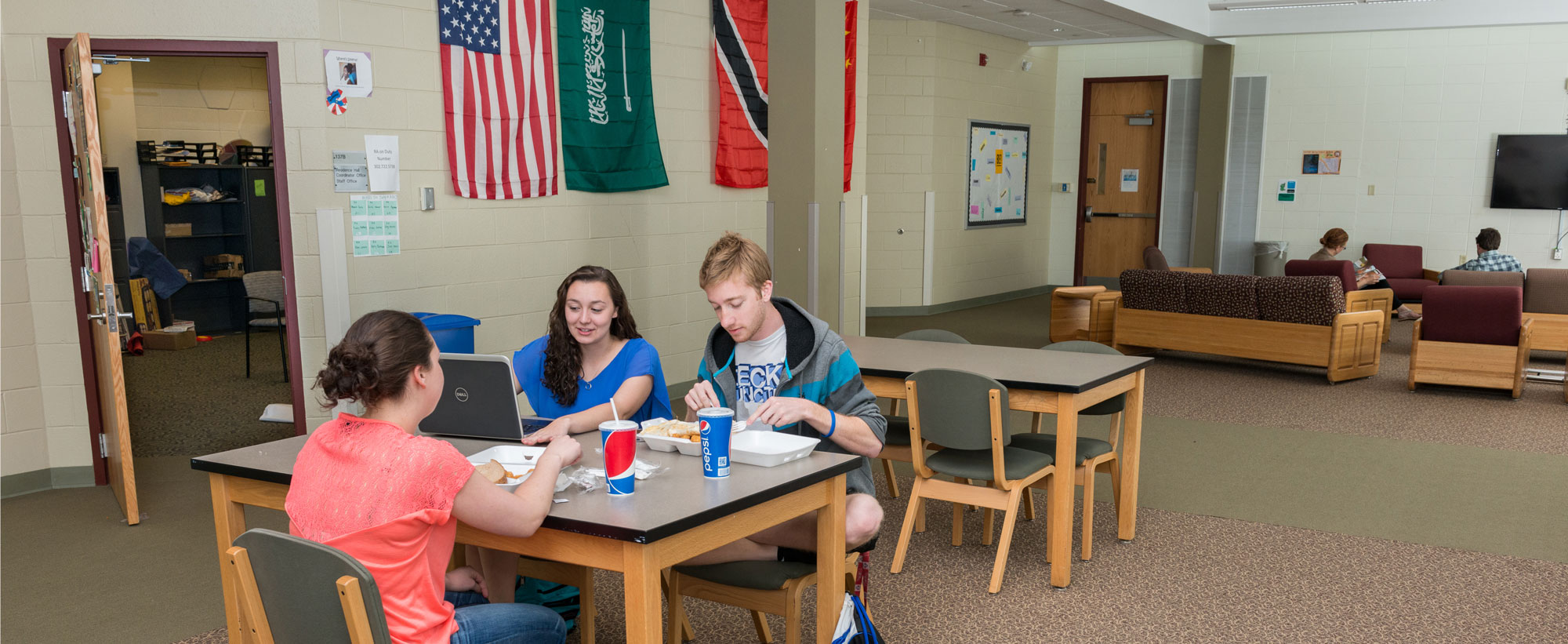 Students eating and working in a Russell Hall lounge space