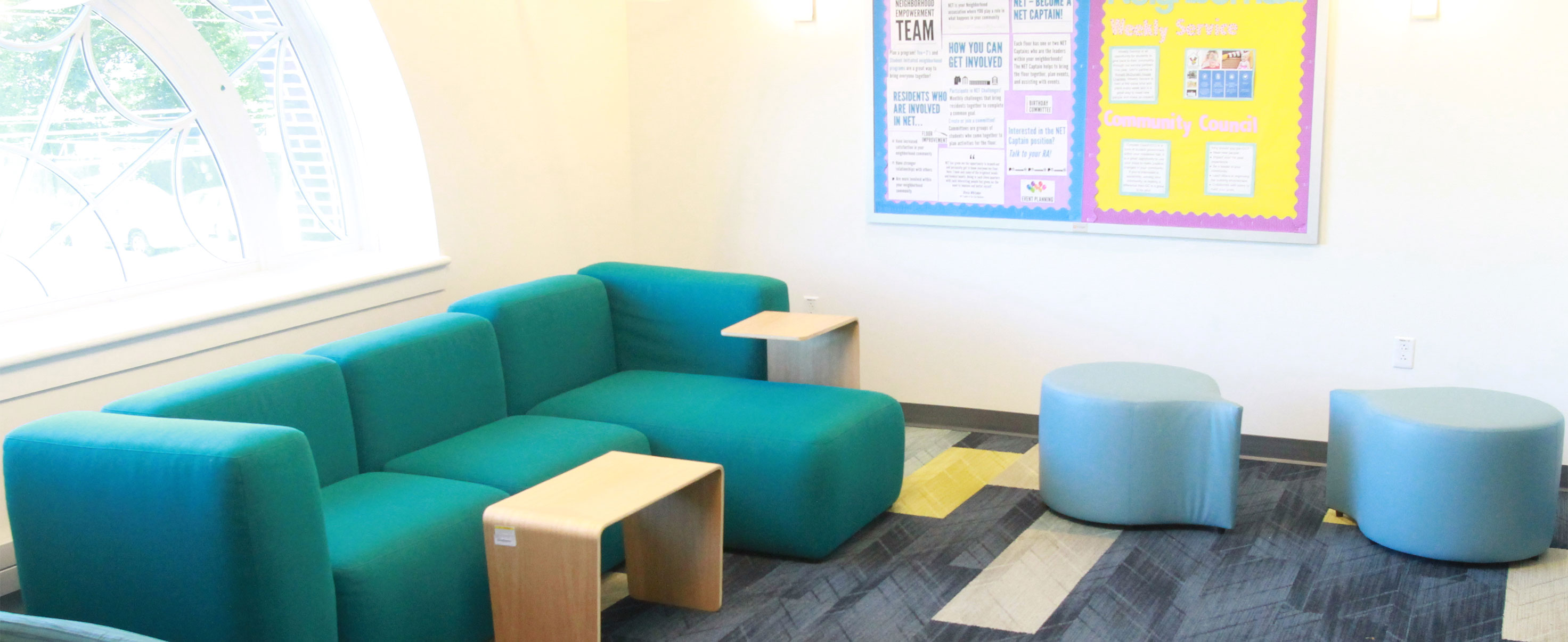Common area with bright colored couches and stools