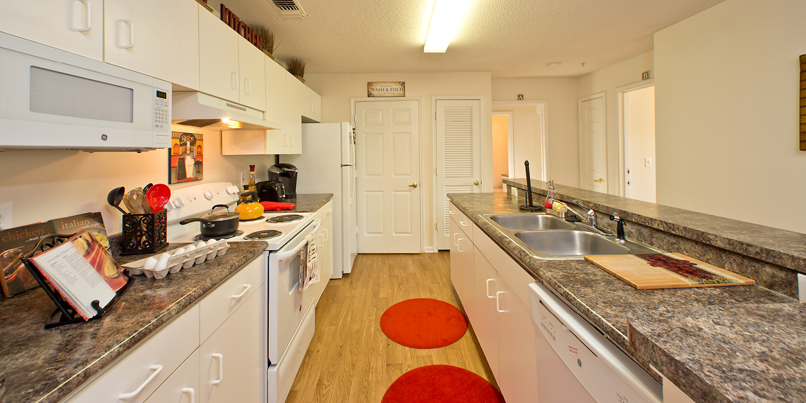 Galley-style kitchen with stove, microwave, dishwasher, fridge and plenty of countertop space
