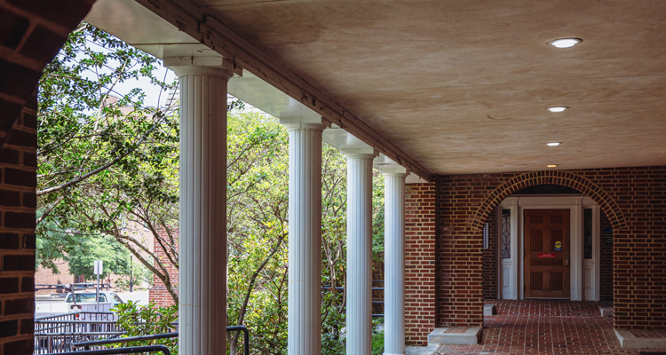 a brick walk-through with columns between South Central buildings