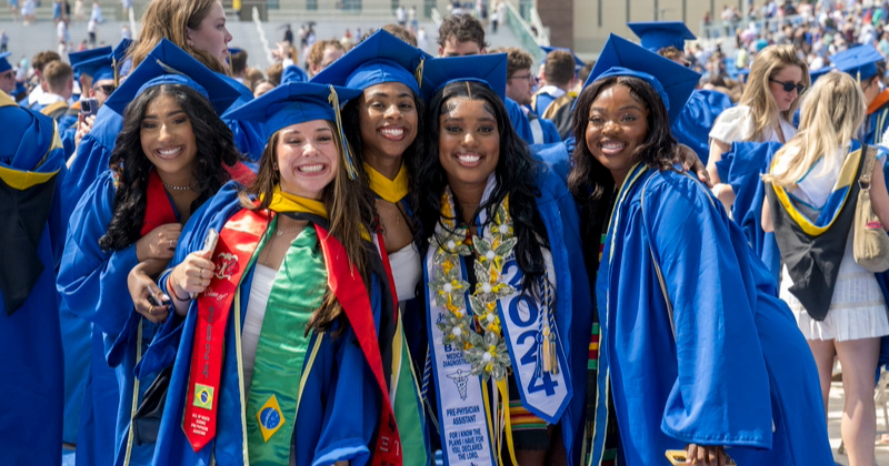 Students pose in caps and gowns at 2024 commencement ceremony