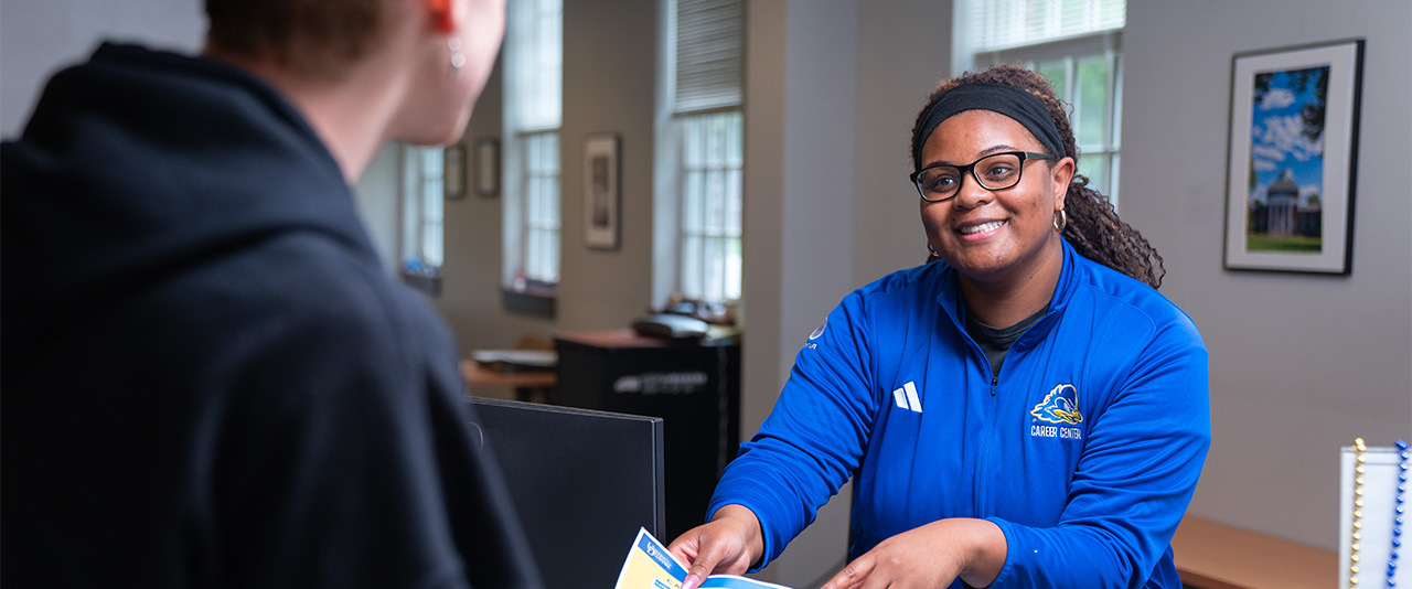 UD Career Center staff person assists a student at the welcome desk