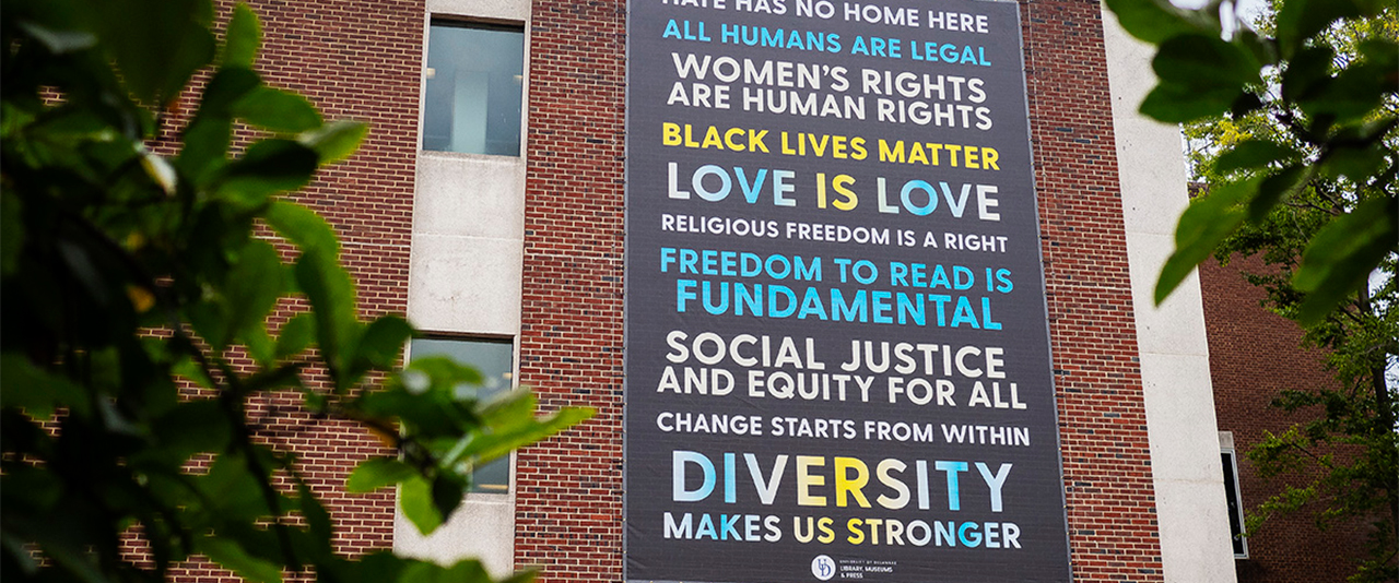 Social Justice banner on the exterior of Morris Library. Photo by Jaynell Keely