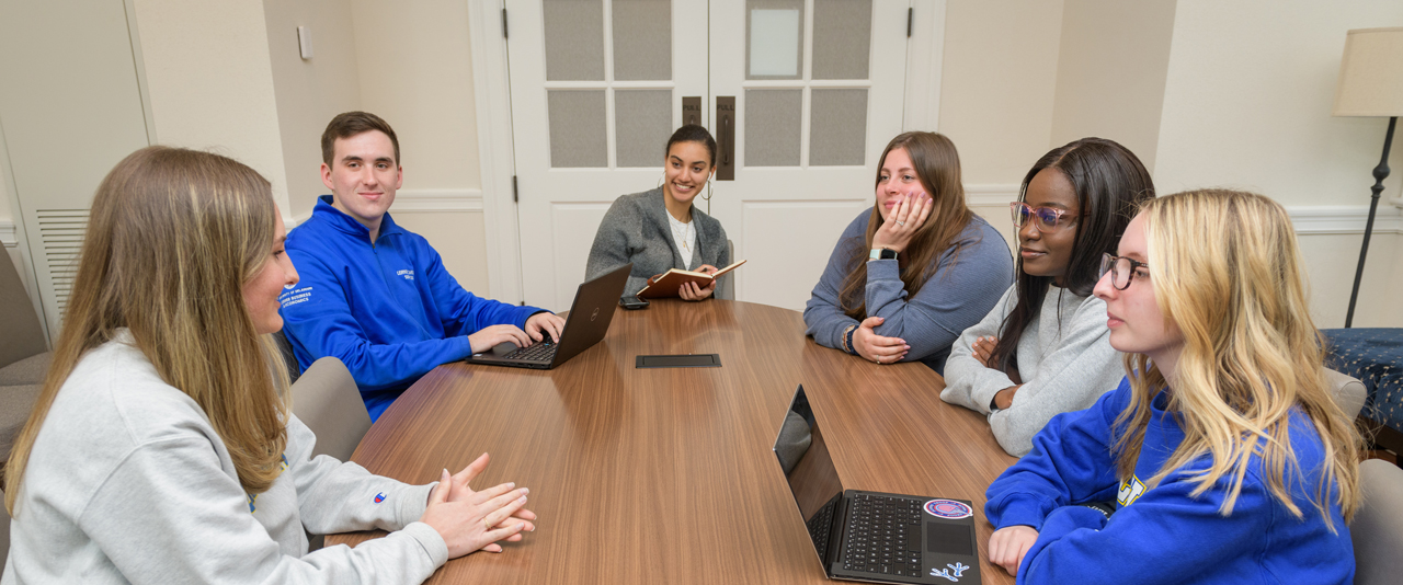 Students gathered around a table and talking