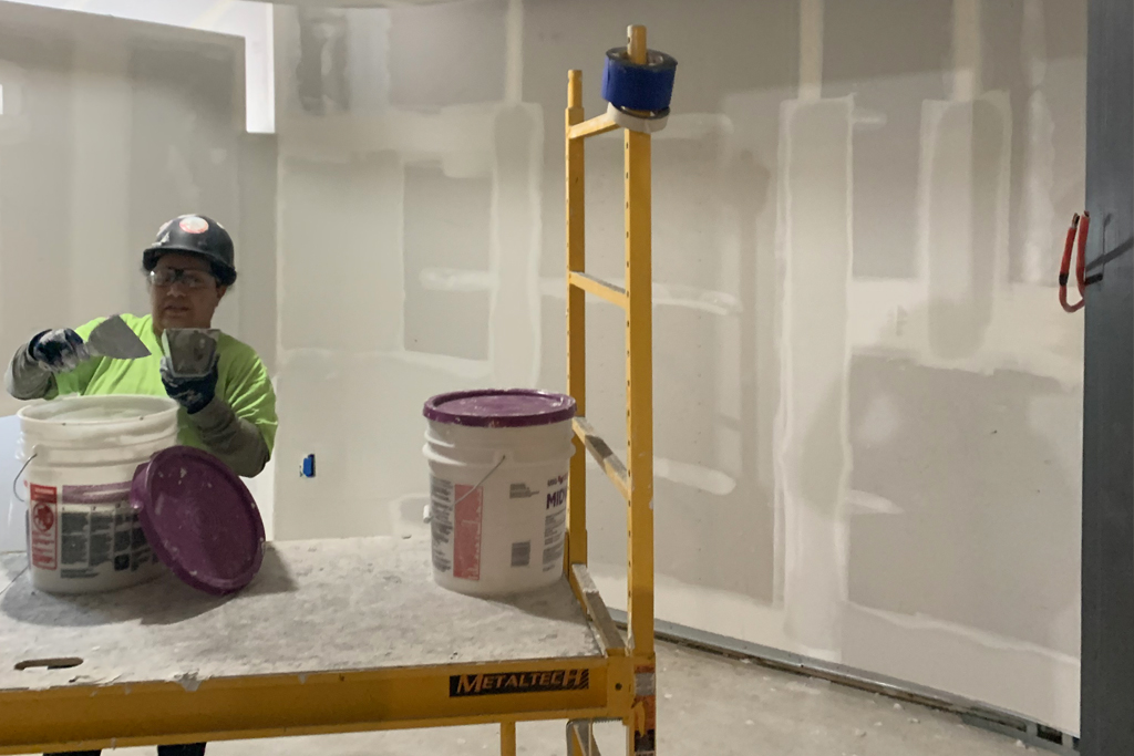 a worker applies spackle in the CIE