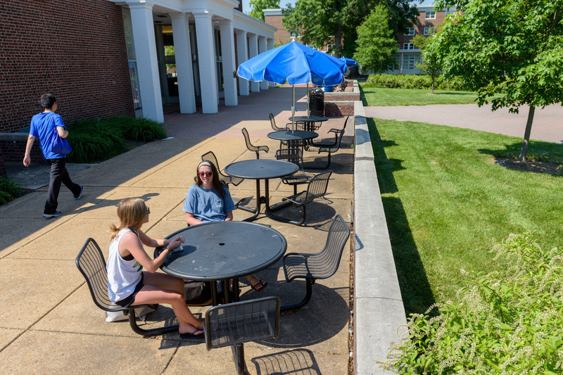 Perkins back patio with round tables and umbrellas