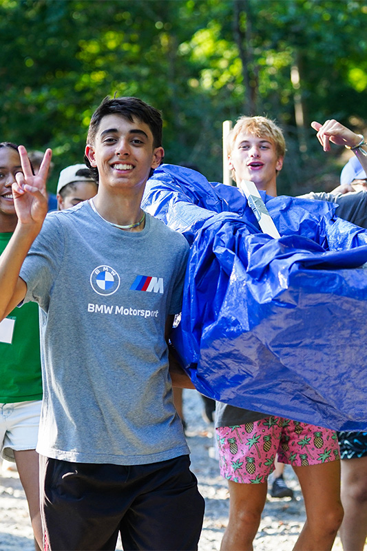 Students carry their homemade boats to the water