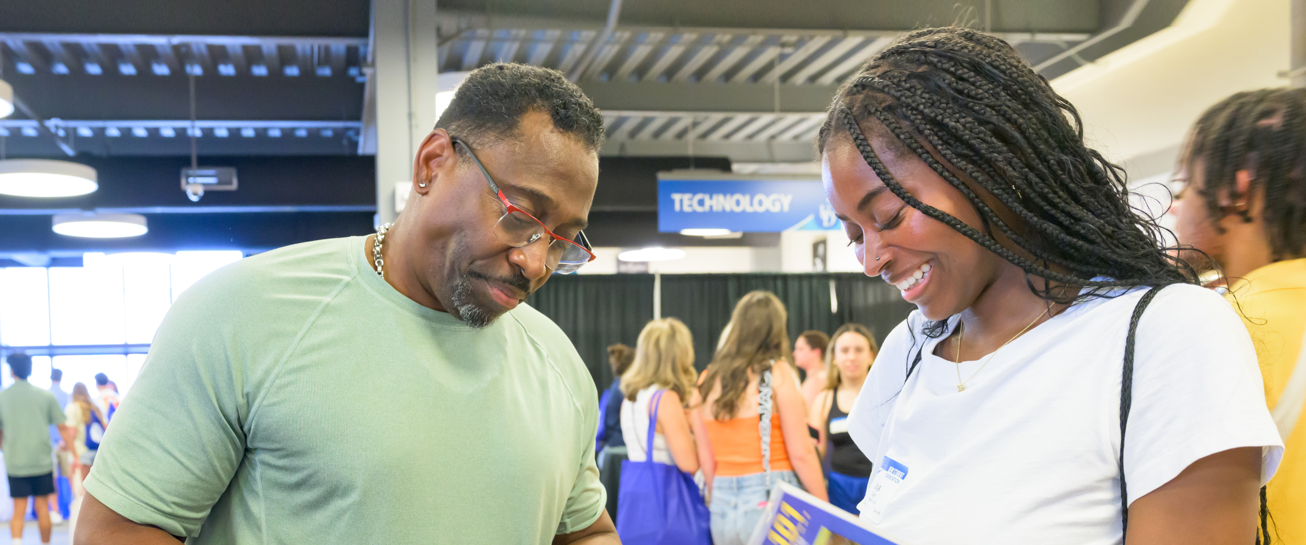 a student and her father look at information at NSO