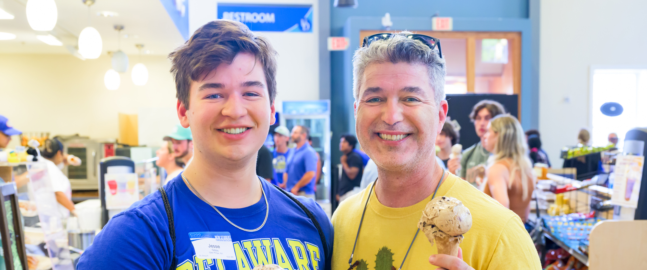 a student and his father pose in the UD Bookstore