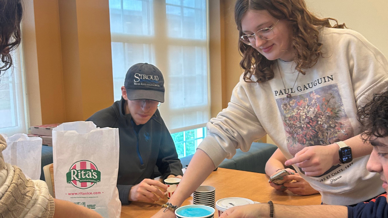 students sit around a table distributing Rita's water ice