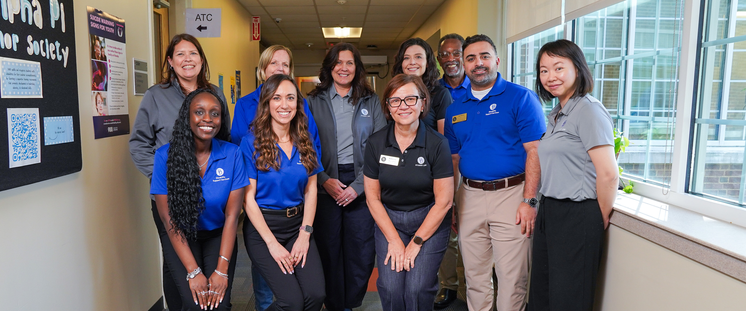 DSS staff pose in the hallway near their office