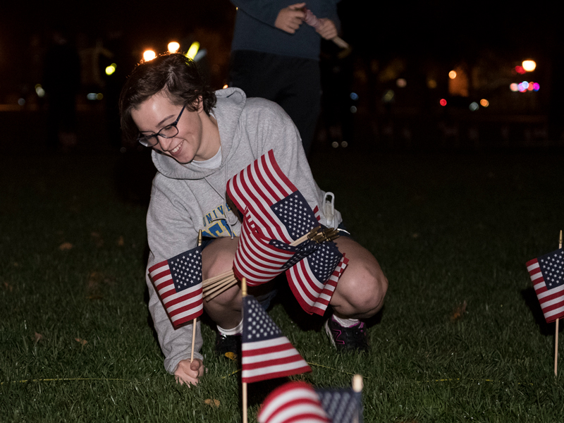 Air Force ROTC cadet Allison Chinnery helps with flag planting on The Green on Monday as part of Veterans Week.