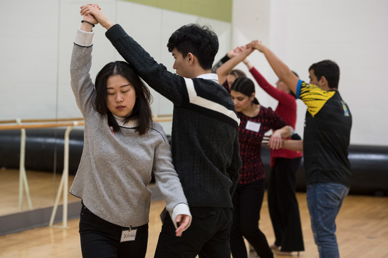 Dance class members practice twirling their partner