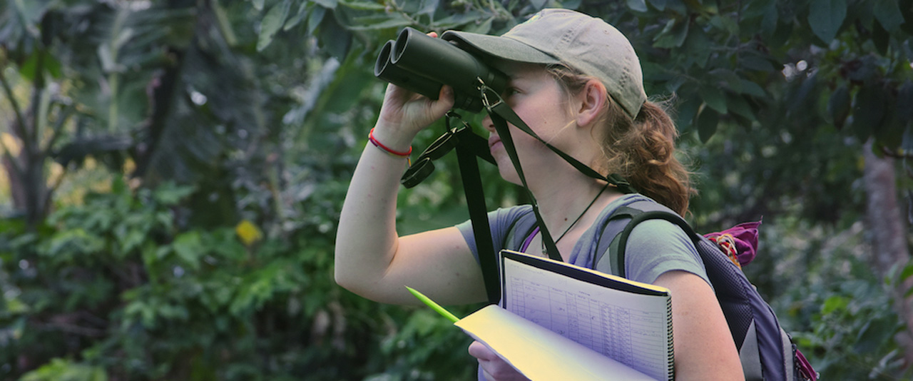 UD student peers through binoculars.