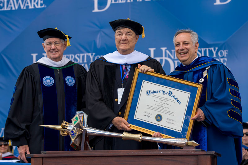 Conservationist and philanthropist Gerret Copeland is congratulated on his new Honorary Doctor of Humane Letters degree by Board Chair John Cochran and President Dennis Assanis.