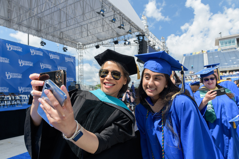 Congresswoman Lisa Blunt Rochester, a UD alumna, takes a selfie with a graduate.