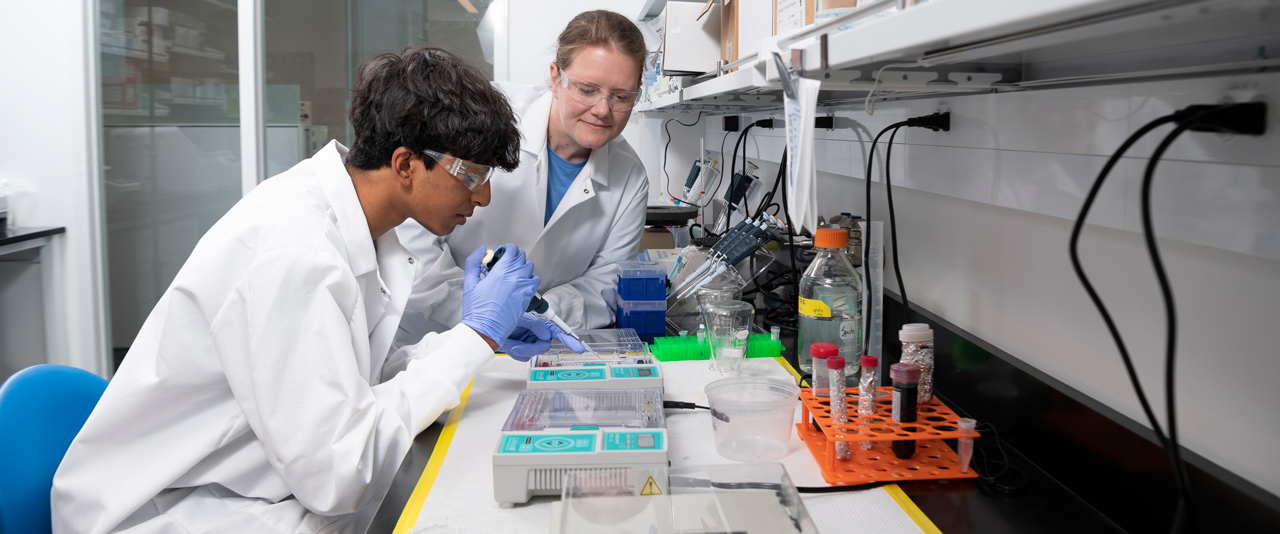 Dheeraj Danthuluri takes a lab sample under the guidance of UD faculty member Erin Sparks. 