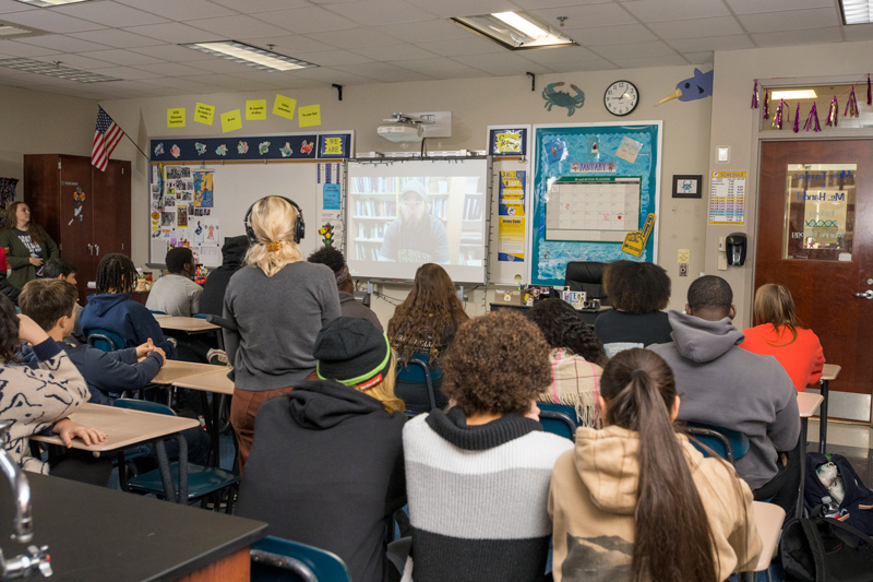 A student wearing headphones asks a question of UD researcher Matt Breece, who is speaking to the class via Zoom from Antarctica.