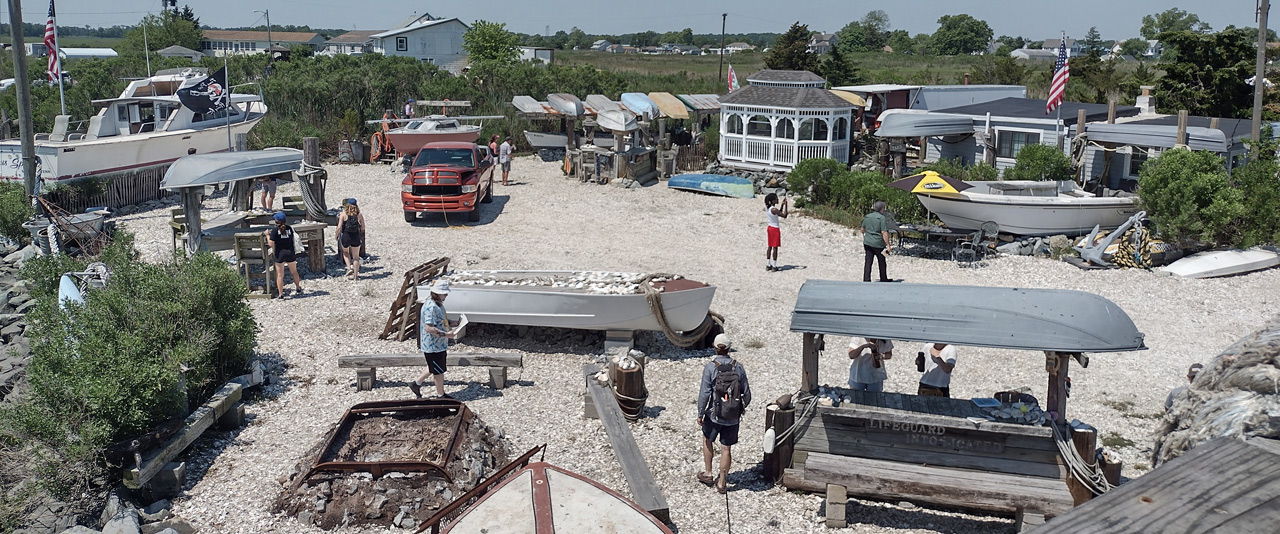 The Coastal Resilience Design Studio summer team for 2022 wander around Paskey's Wharf, discussing the town's fishing history and culture with local community members.