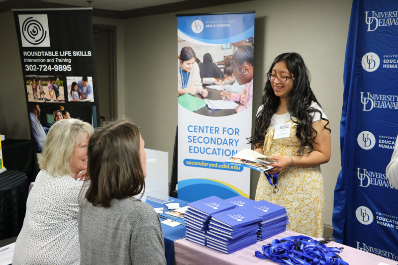 Vickie Lucas, CEHD senior academic advisor, and Kelsey Cummings, CEHD academic program manager, talk with a student interested in a teaching career at the Educators Rising conference. 