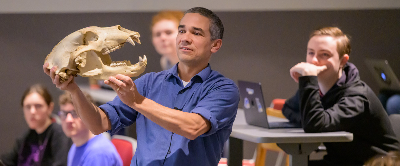 Kyle McCarthy holds an animal skull in front of his class.