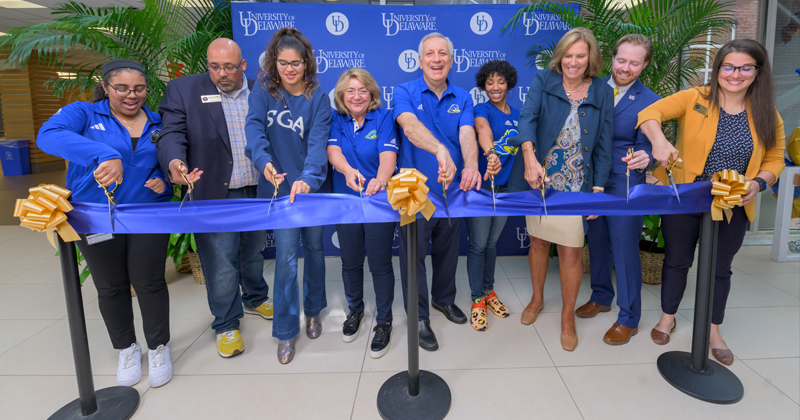 a group of people ready to cut a ribbon outside a building