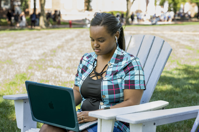 Kiara Holmes does some classwork on the Green before her next class.