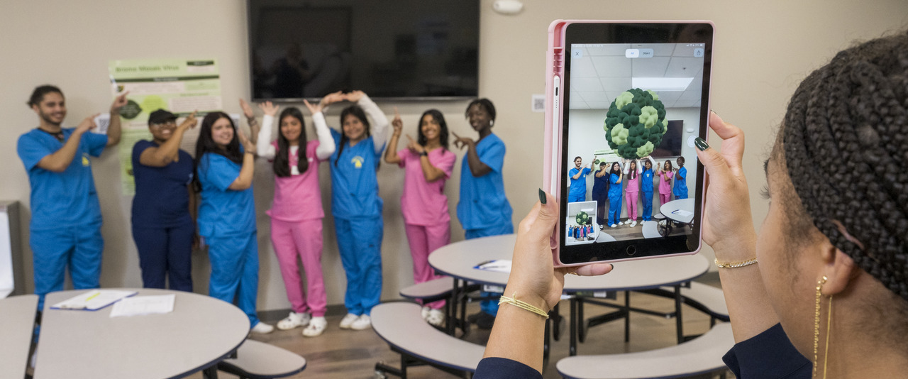 UD students Ava West (creator of the AI program) and Riley Mckeon along with faculty member Lauren Genova help students at Las Américas ASPIRA Academy in Newark learn about viruses through an A.I. exercise which shows what the virus looks like under a microscope that the students can place in photos as a fun way to learn.