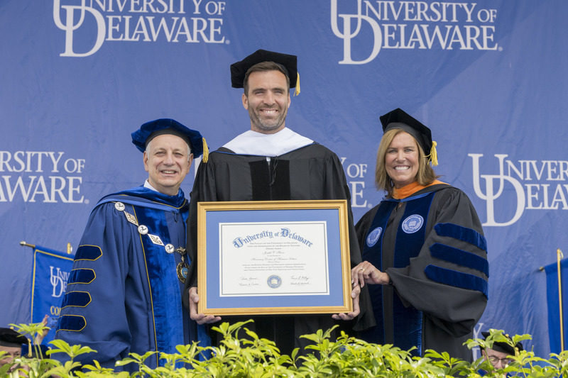 Commencement speaker Joe Flacco, NFL quarterback, Super Bowl MVP and 2008 UD graduate, receives an honorary doctor of humane letters degree from UD President Dennis Assanis (left) and Board Chair Terri L. Kelly (right).