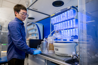 man in laboratory with test tubes and equipment