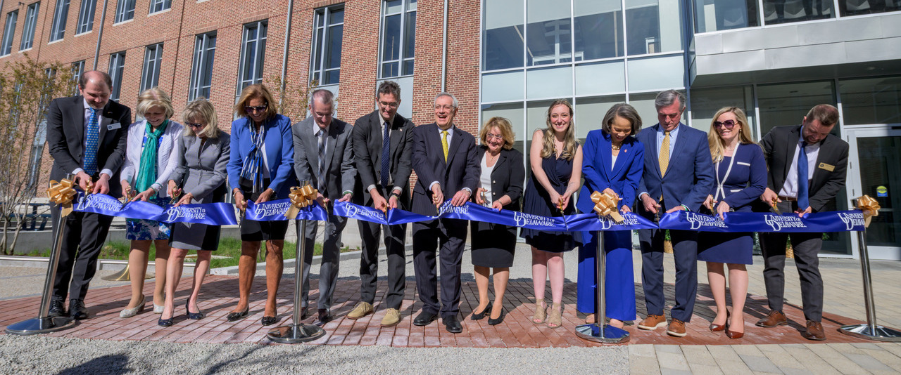 Wielding golden scissors, University of Delaware officials join with faculty, elected officials and a graduate student to cut the proverbial ribbon, marking the official opening of UD’s new Building X. Among them are (left to right) Miguel Garcia-Diaz, vice president for research, scholarship and innovation; Professor Debra Hess Norris, chair and professor in the Department of Art Conservation and a member of UD’s Board of Trustees; Provost Laura Carlson; Terri Kelly, chair of UD’s Board of Trustees; Newark Mayor Jerry Clifton; Delaware Gov. Matt Meyer; UD President Dennis Assanis and first lady Eleni Assanis; doctoral student Skye Brand; U.S. Senator Lisa Blunt Rochester; Wilmington Mayor John Carney; State Treasurer Colleen Davis; and Caleb Everett, dean of the College of Arts and Sciences.