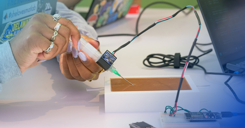  The student team developed a training platform that includes a needle equipped with sensors that register how close the needle came to a “vein” represented by a copper wire embedded in a silicone skin model. 