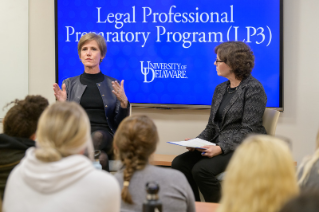 two women sitting in front of lp3 screen