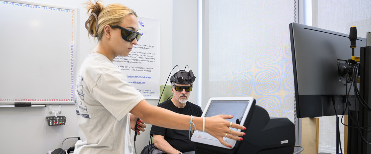 Sara Penuela Rodriguez (left), an interdisciplinary neuroscience doctoral student, administers infrared laser light therapy as part of a blinded study investigating its potential to address Parkinson’s symptoms by improving cellular metabolism and increasing blood flow.