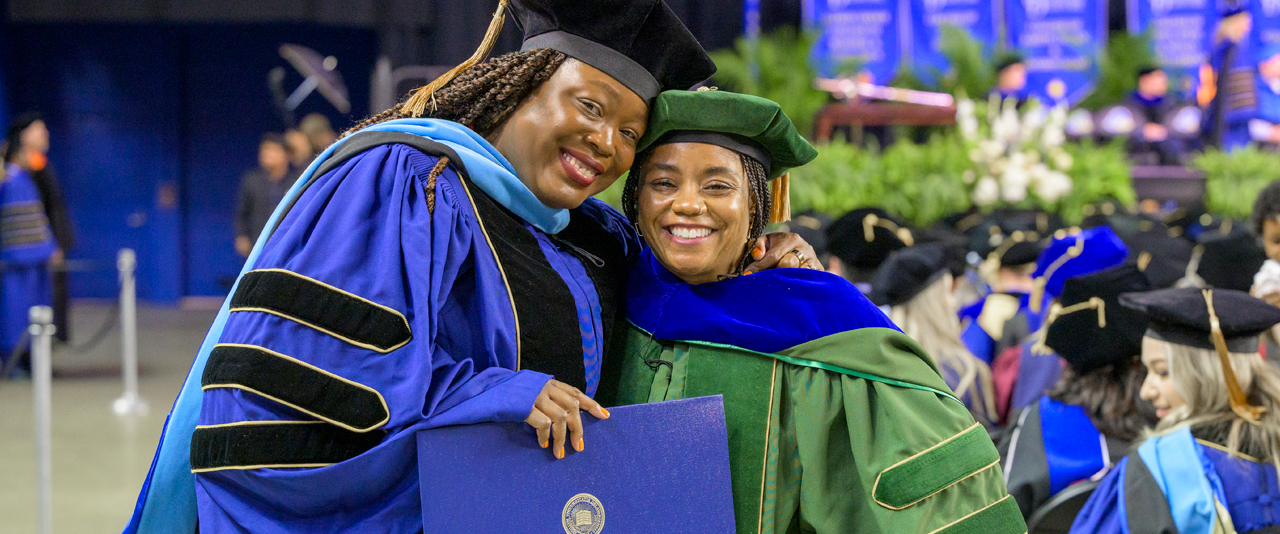The University of Delaware’s May 2025 Doctoral Hooding Ceremony honored about 230 students, including Sophia Vilceus (left), who was hooded by Kisha Porcher.