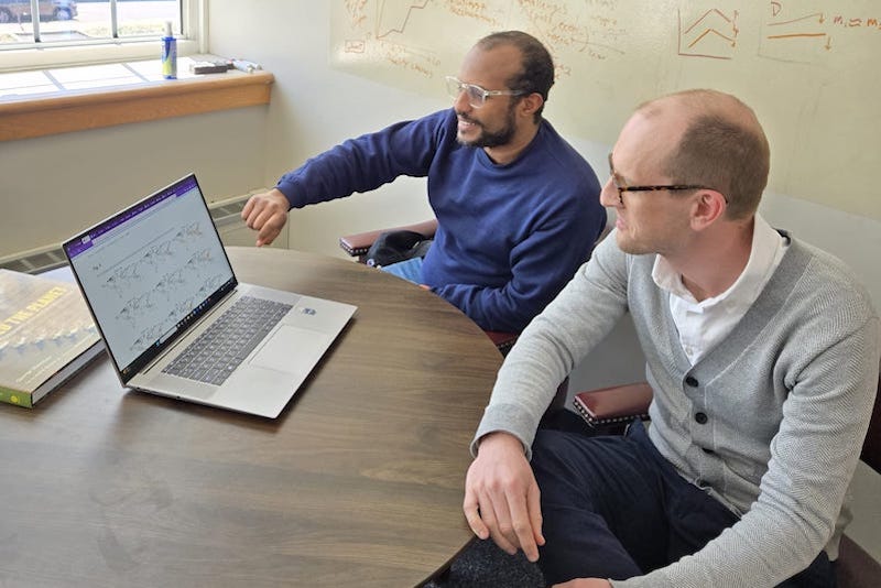 Doctoral student Endalkachew Kebede (left) and Assistant Professor Kyle Davis (right) looking at data on a laptop.