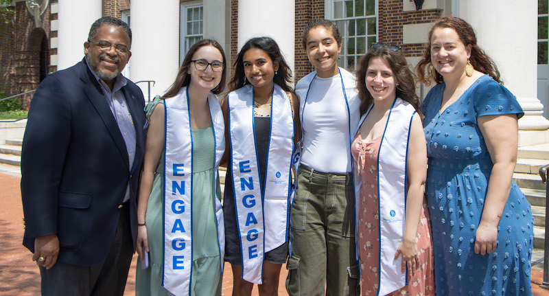 Graduating Community Engagement Scholars Avery Wolverton, Amrutha Veeramachineni, Jasmin Bioteau and Maggie Johnson with Chief Community Engagement Officer Michael Vaughan (far left) and Community Engagement Initiative Assistant Director Leann Moore (far right).
