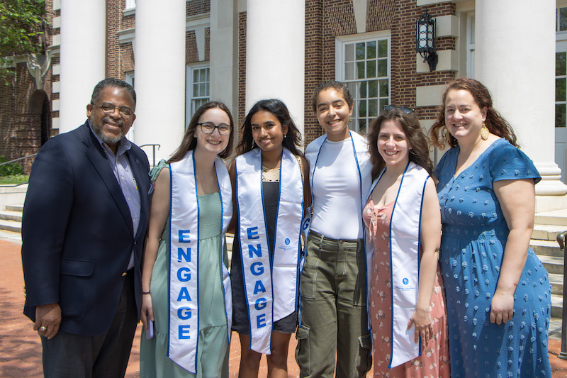 Graduating Community Engagement Scholars Avery Wolverton, Amrutha Veeramachineni, Jasmin Bioteau and Maggie Johnson with Chief Community Engagement Officer Michael Vaughan (far left) and Community Engagement Initiative Assistant Director Leann Moore (far right).