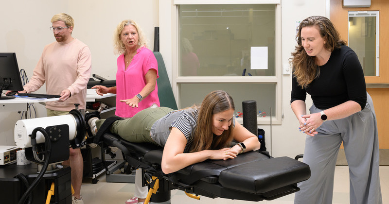 Doctoral candidate Andy Smith and professor Karin Grävare Silbernagel assess doctoral student Madeleine Krotine’s ankle strength, as assistant professor Stephanie Cone offers encouragement.