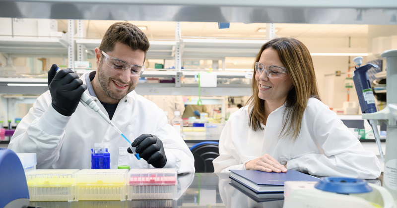 Eric Sterin, a recent UD biomedical engineering doctoral graduate, pipets a solution containing nanoparticles as professor Emily Day looks on. 