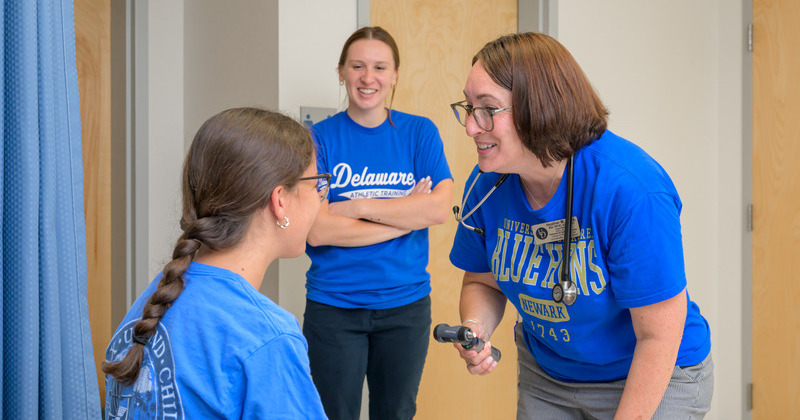 Nurse practitioner Heather Milea (right), clinical lead of the University’s HEALTH for All program, conducts a sports physical at the Newark Charter School while athletic training graduate student Cassie Lee observes. 