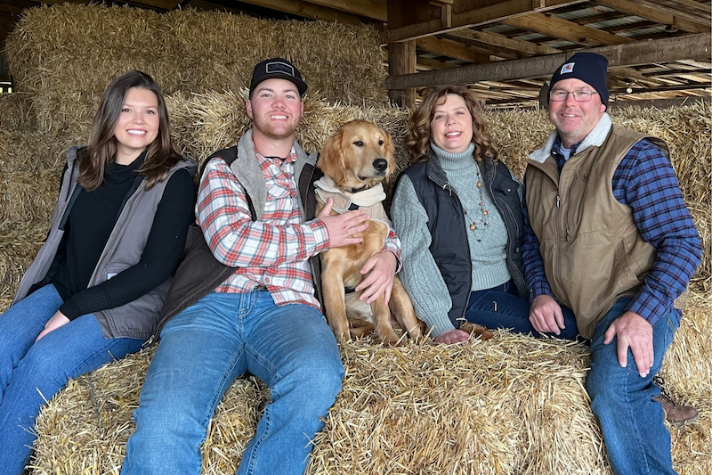 Leslie, Leighton, Elaine and Scott Webb pose on hay bales.