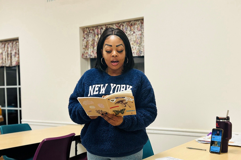 Anastasia Williams reading from a book in writing workshop