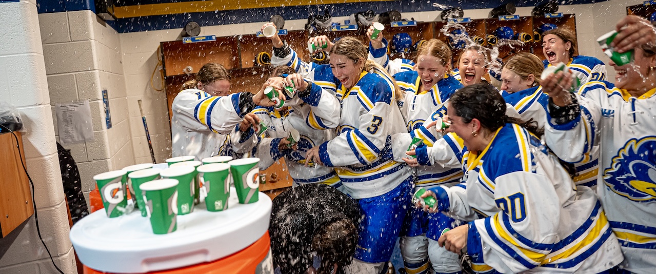 The groundbreaking Division 1 women’s ice hockey team at the University of Delaware, seen here dumping water on Coach Allision Coomey after the first win of the season, has much to celebrate.