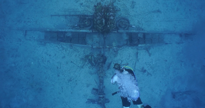 Deep sea diver with World War II wreckage