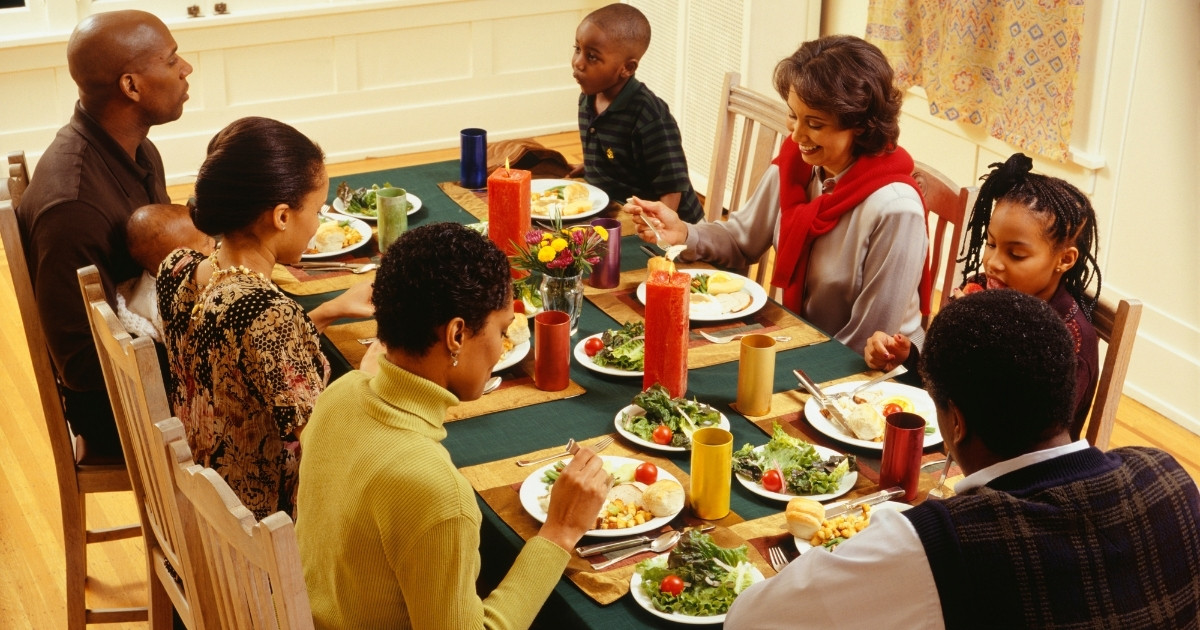 thanksgiving_website_properties_img_extension_1200x630 A family sits around the dining room table to eat Thanksgiving dinner.