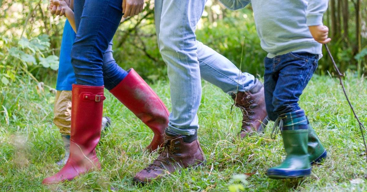 A family hiking in the woods in muddy boots, holding hands!