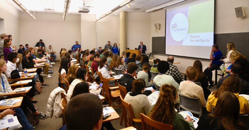 Calvin Keeler and Mark Isaacs address a jam-packed room full of undergraduate students at the college's 2023 career event.